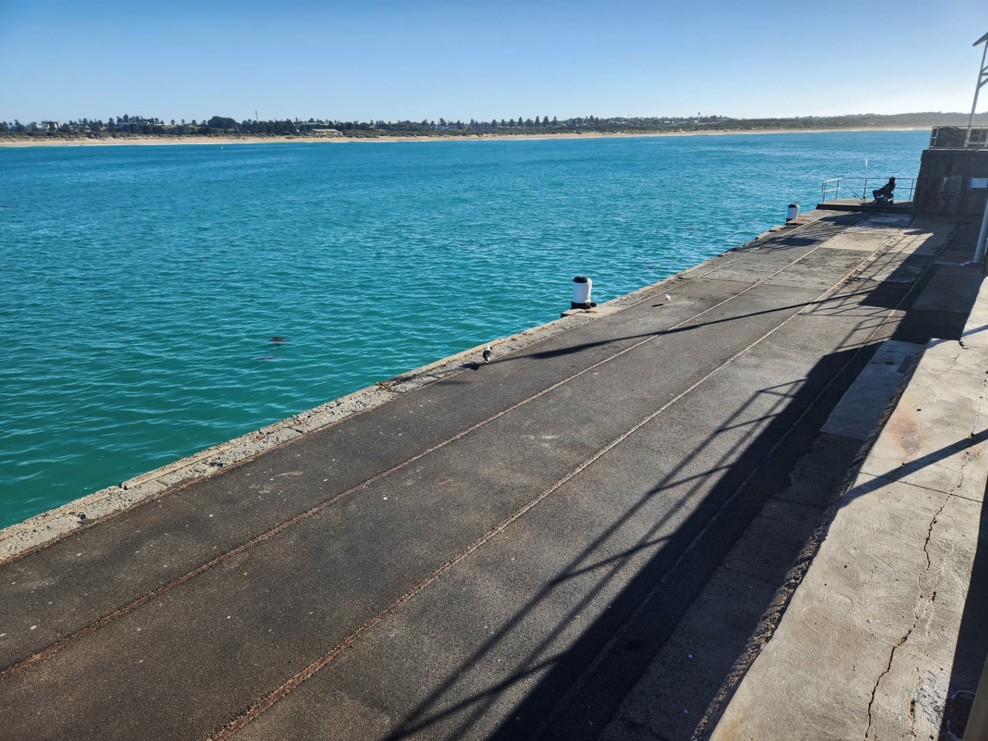 Warrnambool breakwater looking across turquoise water to the coastline